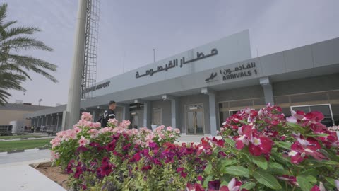 مسافر يسير نحو صالة الوصول في مطار القيصومة