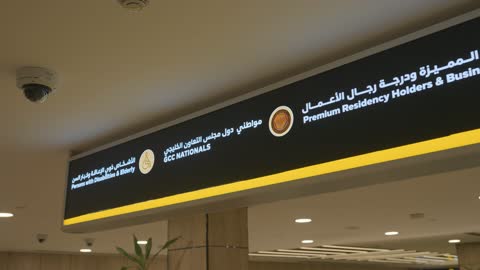 لوحة إرشادية ثنائية اللغة في صالة المطار