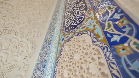 تفاصيل الخط العربي وبلاط الفسيفساء في جدار المسجد
