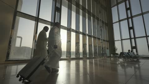 رجال عرب يمشون في صالة مطار حديثة
