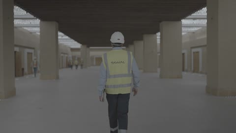 Engineer in Safety Vest Walking Through Warehouse