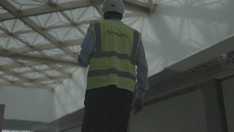 مهندس يسير تحت سقف هندسي في موقع بناء