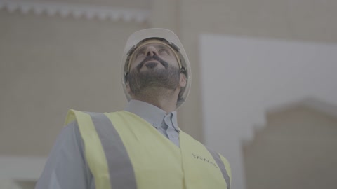 Engineer in Safety Gear Walking on Construction Site