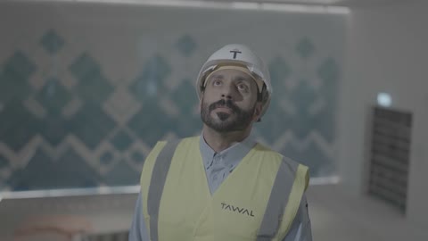 مهندس سعودي يرتدي خوذة وسترة السلامة