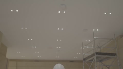 مهندس في موقع بناء داخلي مع لقطة للسقف