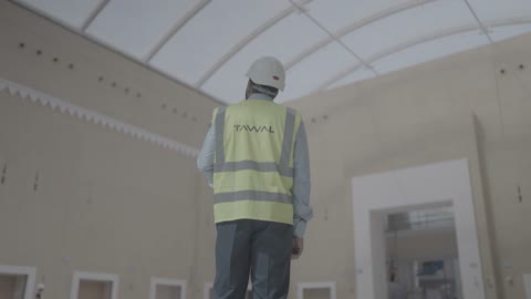 مهندس إنشائي بسترة توال داخل قاعة حديثة