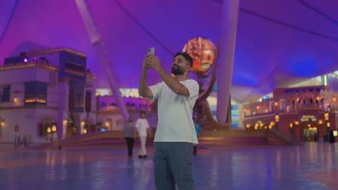 Man Taking Photo with Smartphone in Theme Park