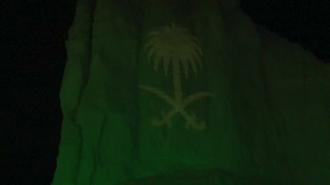 عرض ضوئي لشعار السعودية على جبل في الليل