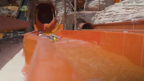 Man Sliding Down Water Slide at Outdoor Water Park