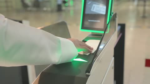 رجل إماراتي يمسح تذكرة الطائرة في بوابة المطار