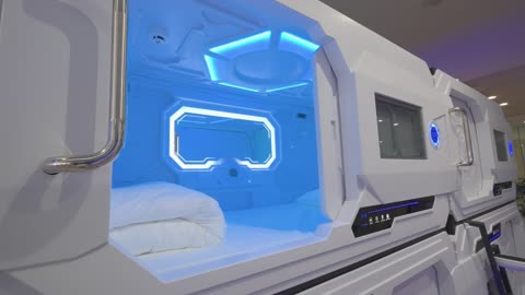 Futuristic Capsule Hotel Sleep Pods with Blue Lighting