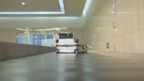 Silver Suitcase Moving on Airport Baggage Carousel