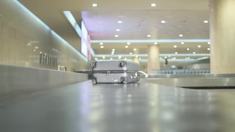Grey Suitcase on Moving Airport Luggage Carousel