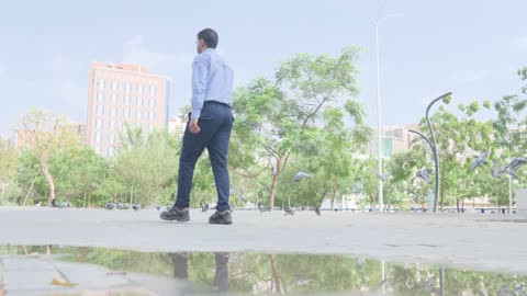 Man Walking in Urban Park with Pigeons Footage