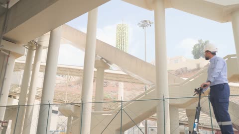 عامل يقود سكوتر كهربائي في منشأة حديثة