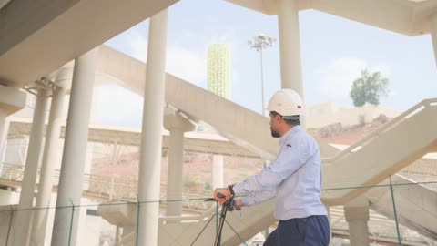 مهندس سعودي يقود سكوتر كهربائي في موقع جسر