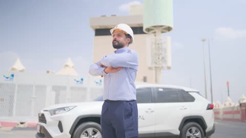مهندس ميداني سعودي يقف بجانب سيارة في موقع عمل