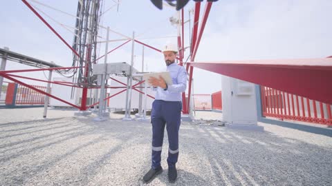 مهندس اتصالات عربي يستخدم جهاز لوحي في موقع البرج
