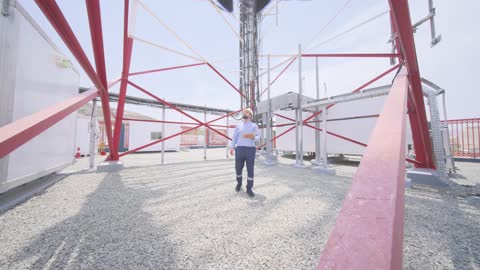 مهندس عربي يفحص برج اتصالات باستخدام جهاز لوحي