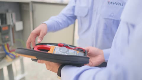 فني كهرباء يستخدم جهاز قياس الأمبير الرقمي