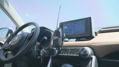 Handheld Two-Way Radio on Car Dashboard Interior