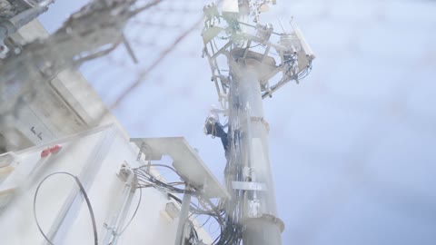 Technician Climbing Cellular Tower for Network Maintenance