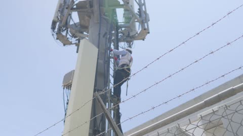 Technician Climbing Telecom Tower for Maintenance