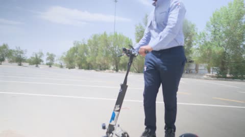 Man Riding Electric Scooter in Outdoor Parking Lot