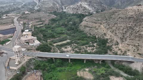 تصوير جوي لجسر فوق وادي أخضر في جبال السعودية