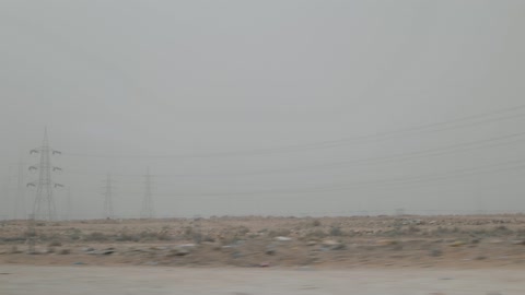 High Voltage Power Lines in Dusty Desert Landscape