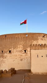 علم سلطنة عمان يرفرف فوق قلعة نزوى التاريخية الأثرية