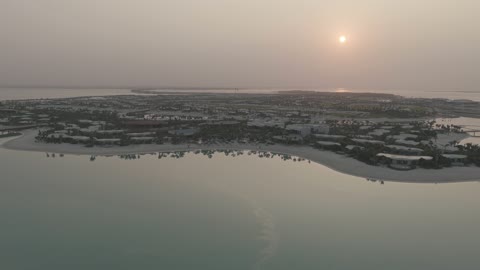 تصوير درون جوي لمنتجع جزيرة فاخر خلال غروب الشمس
