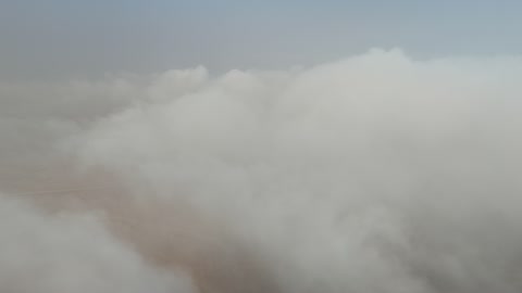 Aerial View Flight Over White Clouds and Desert