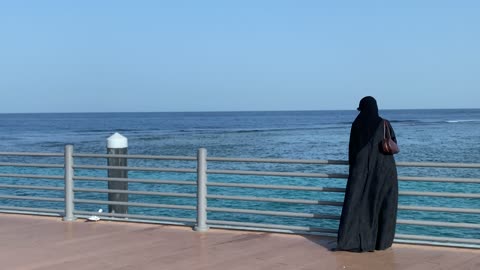 امرأة بالعباءة على كورنيش جدة ساحل البحر الأحمر