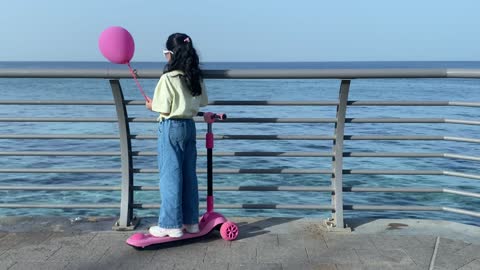 Girl with Scooter and Pink Balloon at Jeddah Corniche