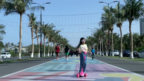 طفلة تركب سكوتر في ممشى كورنيش جدة بالمملكة العربية السعودية