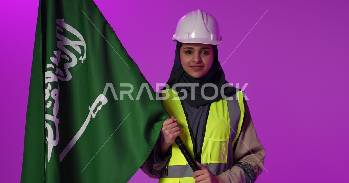 A Saudi Arabian Gulf engineer wearing a protective jacket and safety helmet celebrates the Saudi