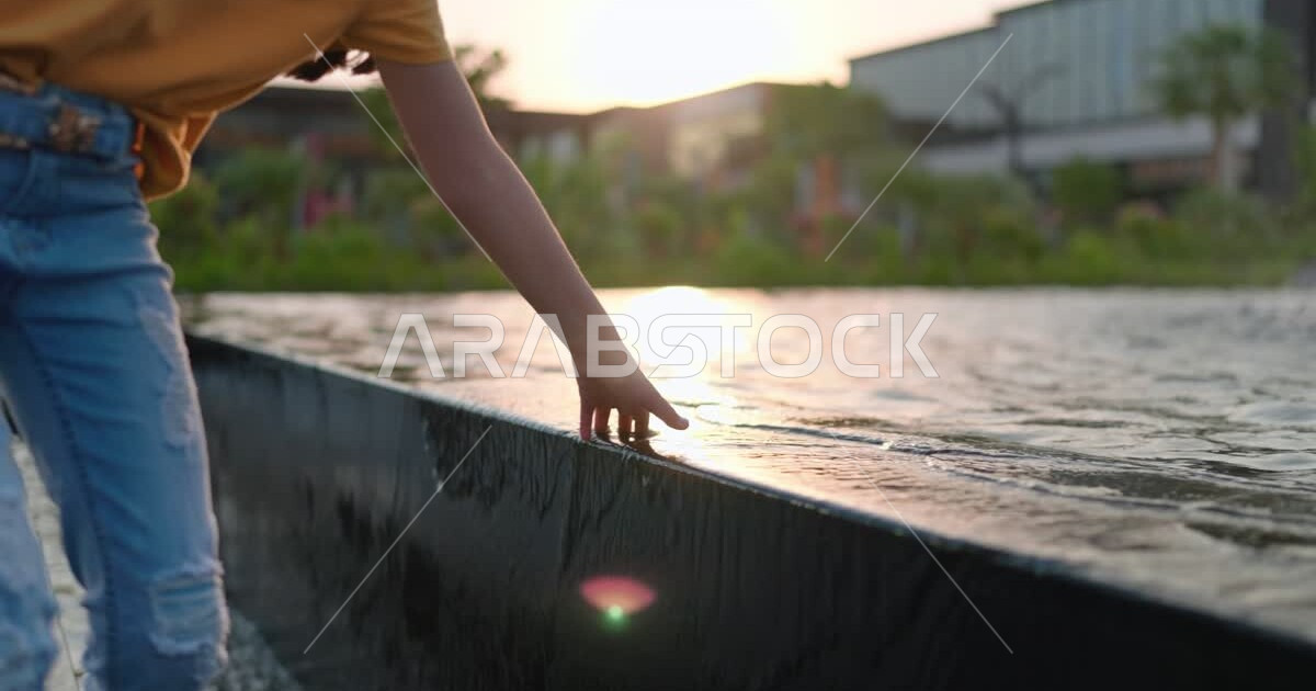 An Arab Saudi Gulf girl running and having fun in the walkway of The ...