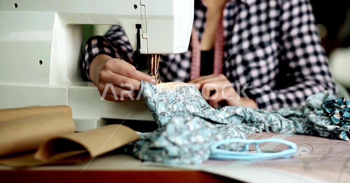 Closeup of a woman cutting and sewing clothes, using a sewing machine