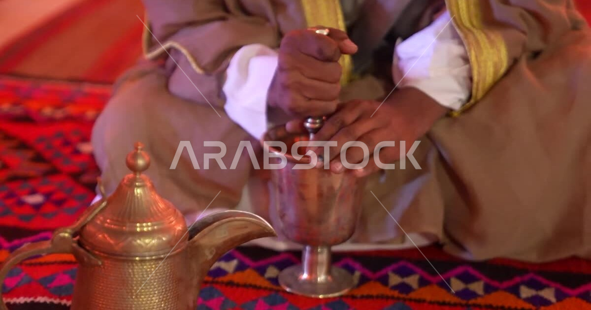 A closeup of a Saudi Arabian Gulf man grinding coffee beans in a