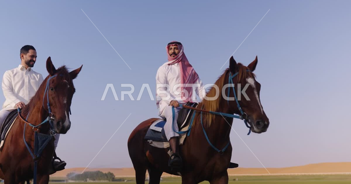 Two Saudi Arabian Gulf men riding horses, purebred Arabian horses