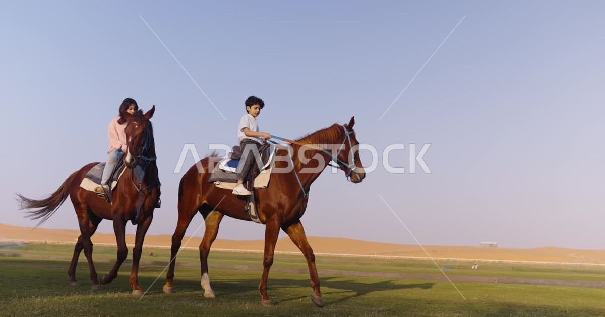 Saudi Gulf Arab boy and girl riding horses, purebred Arabian horses