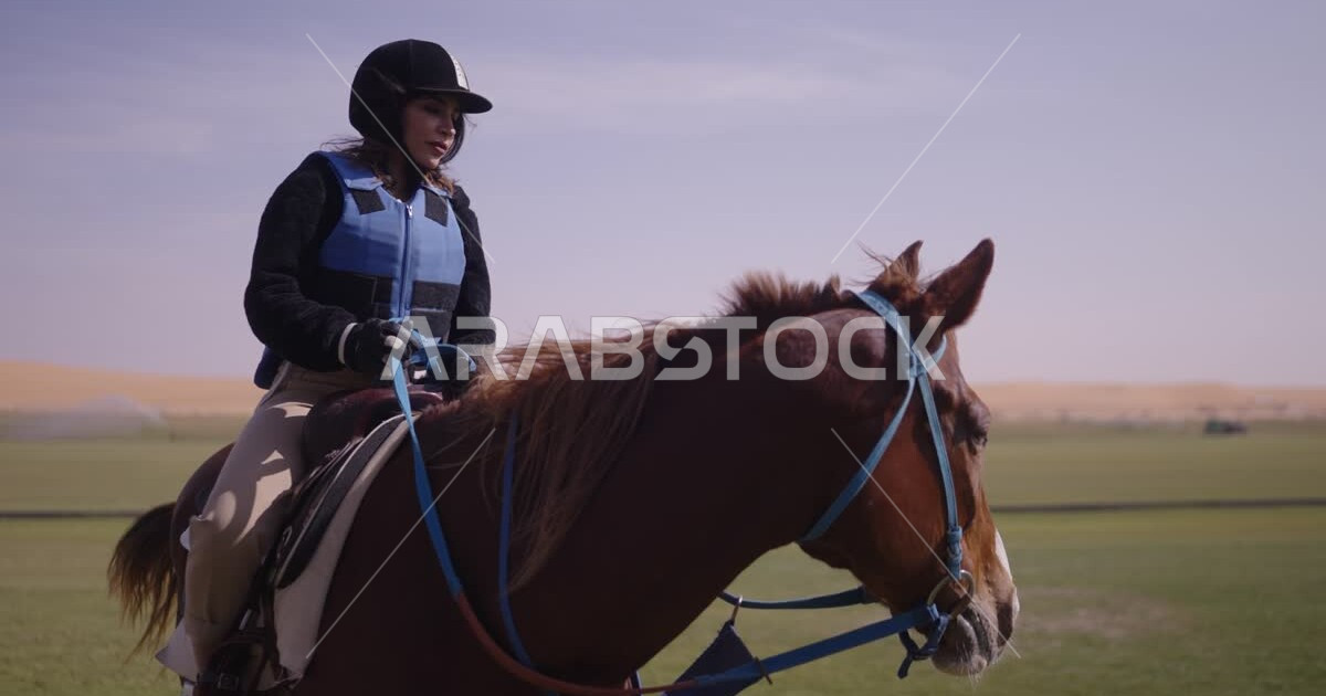 A young Saudi Arabian Gulf woman rides horses, purebred Arabian horses