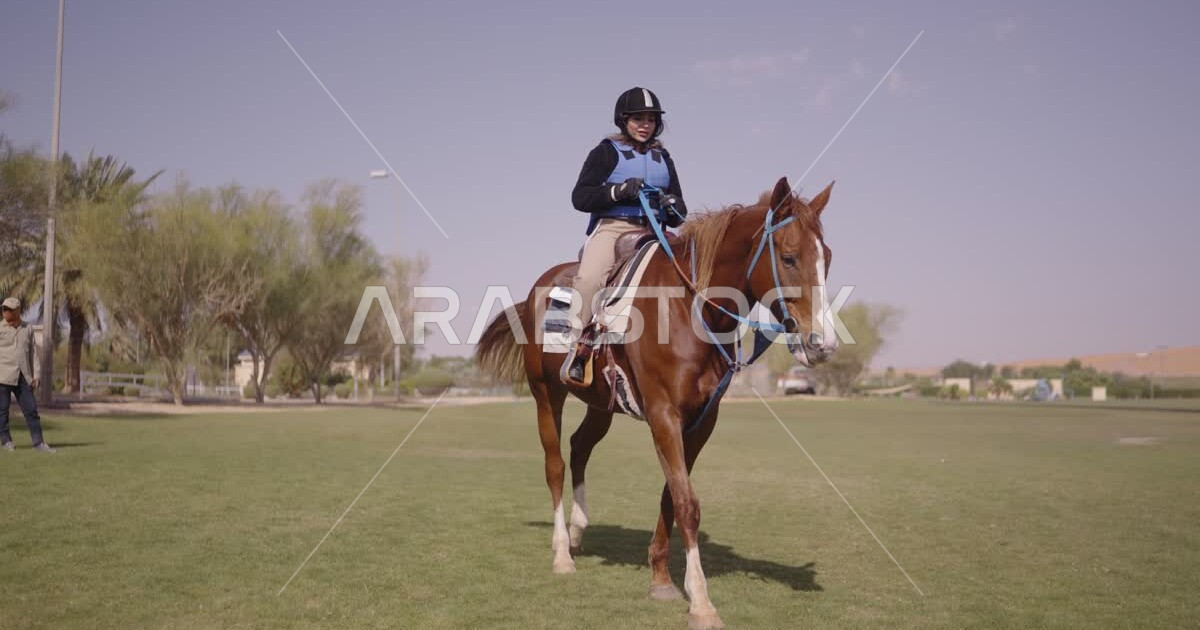 A young Saudi Arabian Gulf woman rides horses, purebred Arabian horses