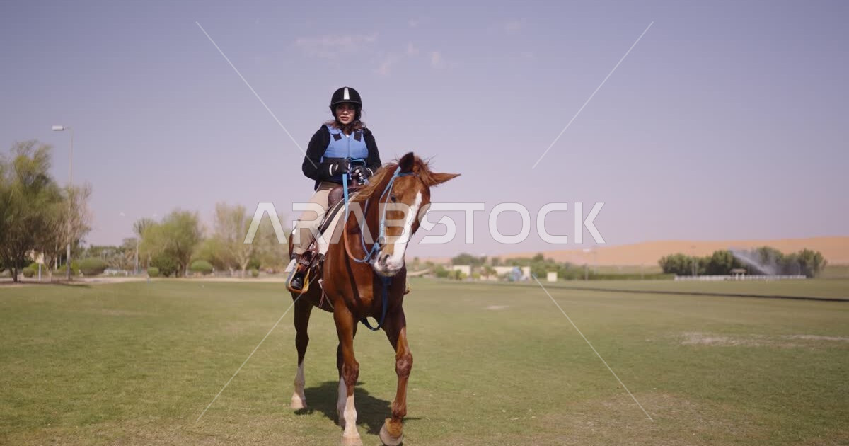 A young Saudi Arabian Gulf woman rides horses, purebred Arabian horses