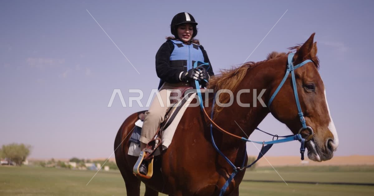 A young Saudi Arabian Gulf woman rides horses, purebred Arabian horses