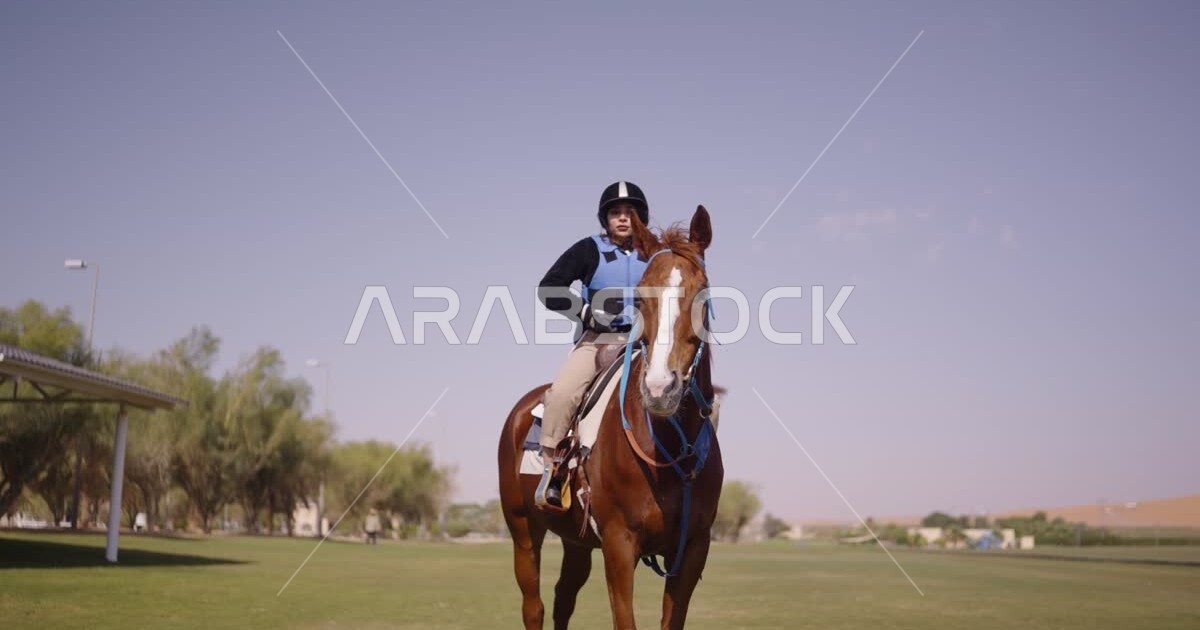A young Saudi Arabian Gulf woman rides horses, purebred Arabian horses