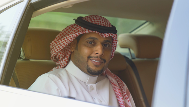 A Saudi Arabian Gulf renter inside the car raises the thumbs up, a passenger admires the green taxi services, the safe passenger delivery service, the green taxi in Saudi Arabia